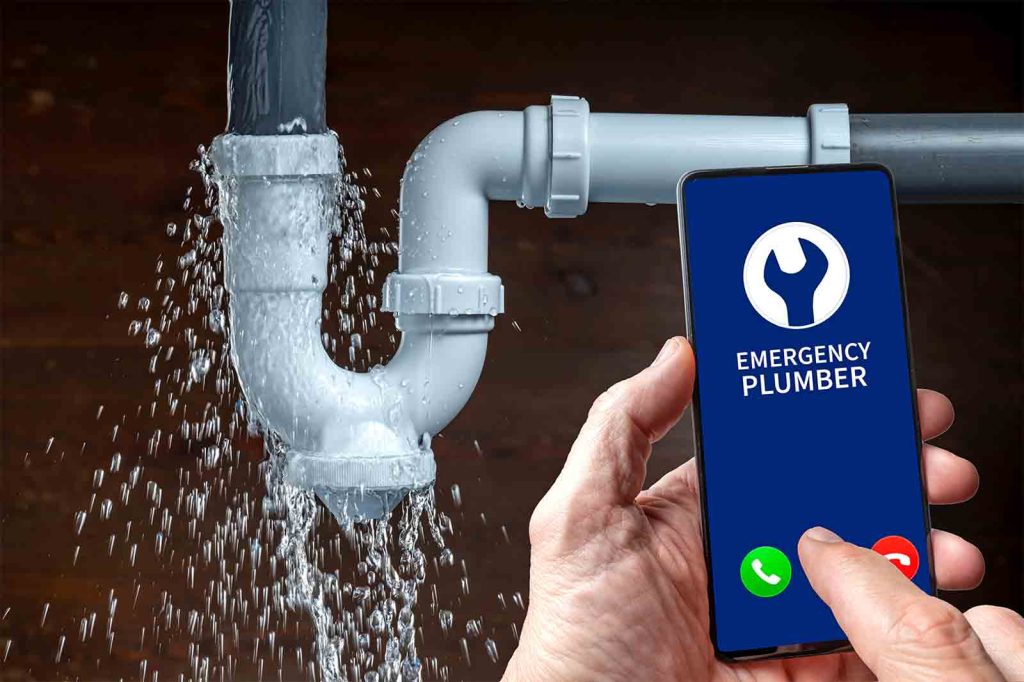 plumber-seo | localfind.us hand holding a smartphone displaying a blue screen that reads 'emergency plumber' beside a leaking pipe, indicating an urgent plumbing service.